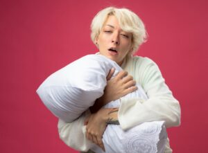 menopauza a spánek - ospalá žena s polštářem